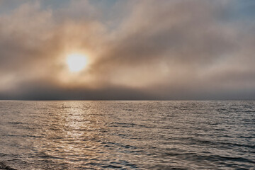 Sunset in fog on Lake Baikal, Buryatia, Russia. Dramatic sky.