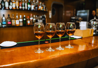 Wine glass glasses with alcoholic cocktails stand on a wooden table in a bar, cafe, restaurant.