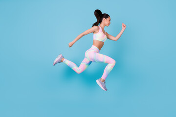Fototapeta na wymiar Full length photo of purposeful strong woman dressed sport costume jumping up running fast isolated blue color background