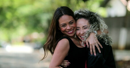 Happy girlfriends joy and embrace, two friends hug feeling happy