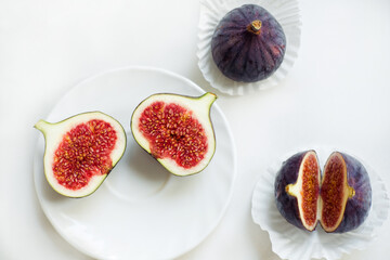 cut and whole figs on a plate, On a white background. Flat lay, Top view. Copy space.