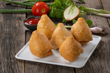 Fried indian dish singaraa.Indian Delicious Deep Fried Breakfast Samosa Also Know as Samoosa isolated on Wooden texture Background