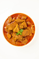 Beef masala or roast,kerala style homemade recipe garnished with coconut pieces and curry leaves which is arranged in white bowl with white background
