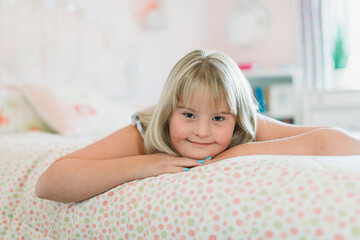 Beautiful little child girl in a dress having great time on her pink bedroom