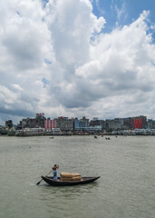 Obraz premium Beautiful landscape of Sadarghat river port on Buriganga river in Dhaka. Ferry boats on the river with a cloudy sky background.