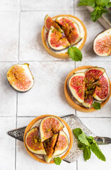 Tasty tartlets with cream cheese and figs on grey tilled background. Cooking concept. Healthy dessert.