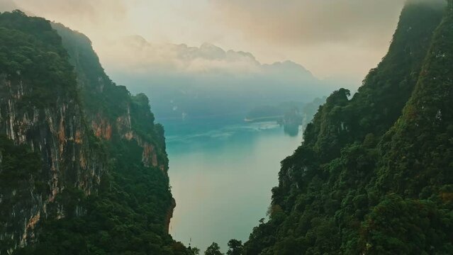 Aerial drone pull back shot over mountain and lake in Khao Sok park, Thailand