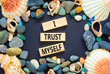 I trust myself symbol. Concept words I trust myself on wooden blocks. Sea stone, seashell....