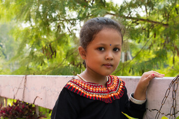 Indian girl in black traditional clothes smiling and lookin at camera, welcome expression of...