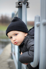 boy looks over the fence at the river