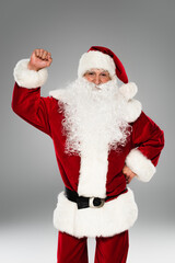 Fototapeta na wymiar Bearded santa claus showing yes gesture and looking at camera isolated on grey.