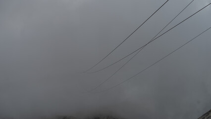 Cable car cables  coming out of the clouds in Austrian Alps glacier
