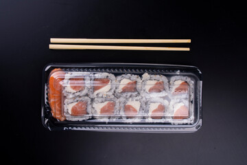 japanese oriental food delivery with closed plastic packaging and raw salmon suhsis with cream...