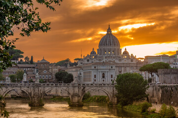 Fototapeta na wymiar Panoramic View of the Dome of the Basilic of Saint Peter in Rome beside the Bridge on the Tevere River in Rome at Sunset