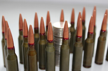 Rows of gun bullets with blurred coins column inside a rows stock photo. Conceptual photo demonstrating the idea that money can be a weapon
 - obrazy, fototapety, plakaty