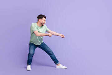 Fototapeta na wymiar Full length photo of nice young guy pulling empty space contest sportsman wear trendy gray clothes isolated on violet color background