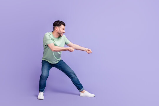 Full length photo of nice young guy pulling empty space contest sportsman wear trendy gray clothes isolated on violet color background