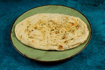 Roghni naan, khamiri roti, kulcha, bread, or chappati served in a dish isolated on background top view