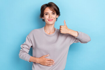 Photo of pretty charming stylish lady raise arm show okey symbol touch tummy stomach enjoy healthy...