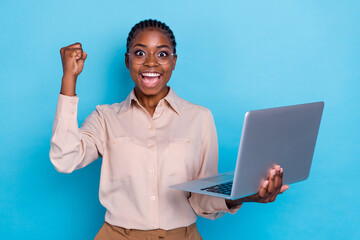 Photo of overjoyed young businesswoman working in laptop celebrate her promotion isolated on blue color background