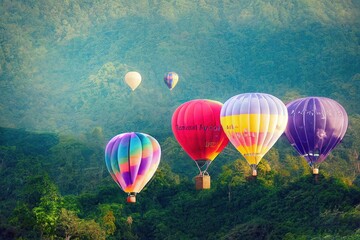 Obraz na płótnie Canvas Colorful hot air balloon flying over mountain