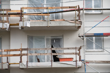 Detail shot of the facade of a new house under construction. The balconies are provisionally...