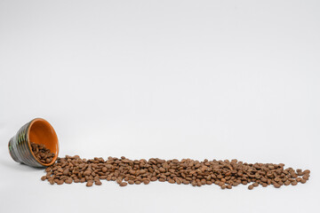 Path of coffee beans spilled from a mug, coffee on an isolated white background.