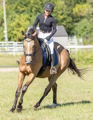 Foto op Canvas An equestrian rides her horse for a dressage warmup.  © FastHorsePhotography