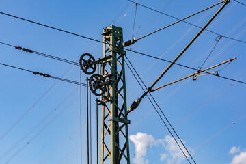 Several cables, wires and gears on a pole for overhead lines for railroads