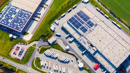 Industry with low carbon footprint. Industrial warehouses with solar panels on the roof. Technology park and factories  from above. © Kletr