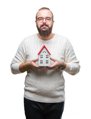 Young caucasian real state agent man holding house isolated background with a confident expression...