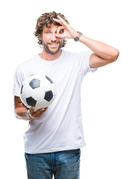 Fototapeta Handsome hispanic man model holding soccer football ball over isolated background with happy face smiling doing ok sign with hand on eye looking through fingers