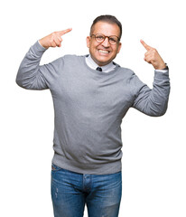 Middle age bussines arab man wearing glasses over isolated background Smiling pointing to head with both hands finger, great idea or thought, good memory