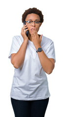 Young african american woman talking on the phone over isolated background cover mouth with hand shocked with shame for mistake, expression of fear, scared in silence, secret concept