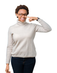 Young beautiful african american woman wearing glasses over isolated background Pointing with hand finger to face and nose, smiling cheerful