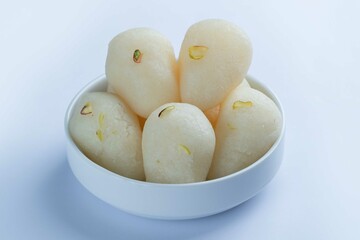 Naklejka na ściany i meble Rassgulla or Rosogolla in a bowl or plate. Made from ball shaped dumplings of chhena and semolina dough, cooked in light syrup made of sugar. Popular in west bengal and Assam.
