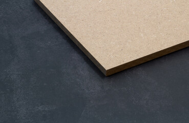 Part of a raw mdf board on a dark background.