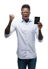 Young african american man holding australian passport annoyed and frustrated shouting with anger, crazy and yelling with raised hand, anger concept