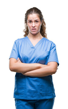 Young brunette doctor girl wearing nurse or surgeon uniform over isolated background skeptic and nervous, disapproving expression on face with crossed arms. Negative person.