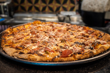 Italian food - pizza with salami, cheese and tomatoes, close-up