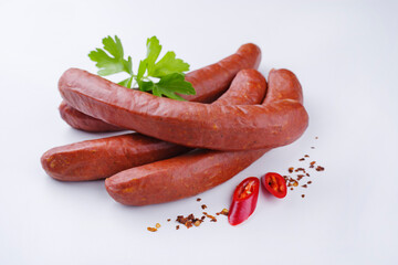 Traditional raw Bavarian spicy bratwurst with chili offered as close-up on rustic white board with...