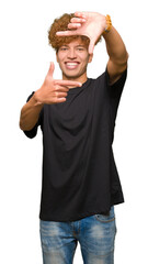 Young handsome man with afro hair wearing black t-shirt smiling making frame with hands and fingers with happy face. Creativity and photography concept.