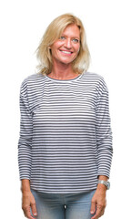 Middle age blonde woman over isolated background looking away to side with smile on face, natural expression. Laughing confident.