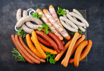 Traditional raw grill platter with different types of bratwursts prepared for a summer barbecue...
