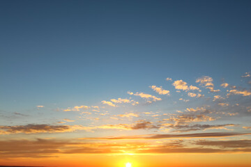 Cumulus sunset clouds with sun setting down