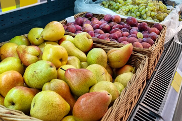 Green pears in box in grocery department of supermarket, store, shop, shopping center. Sweet summer fruit Close up shot