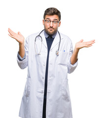 Young handsome doctor man over isolated background clueless and confused expression with arms and...