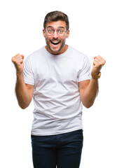 Young handsome man wearing glasses over isolated background celebrating surprised and amazed for success with arms raised and open eyes. Winner concept.