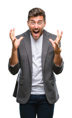 Fototapeta premium Young handsome business man over isolated background celebrating crazy and amazed for success with arms raised and open eyes screaming excited. Winner concept