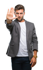 Fototapeta premium Young handsome business man over isolated background doing stop sing with palm of the hand. Warning expression with negative and serious gesture on the face.